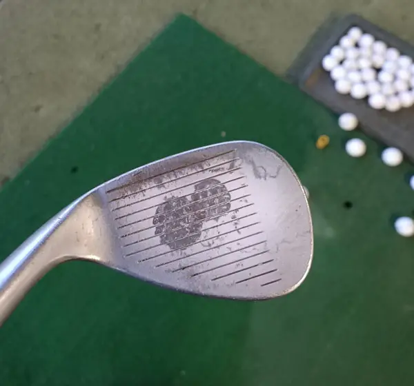 Where should the golf ball hit the club face?